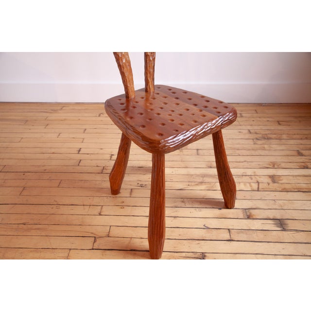 Meticulously carved chair in the style of Alexandre Noll. This singular chair effortlessly combines the functions of a...