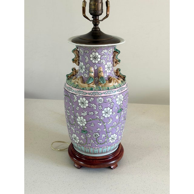 This lovely vintage Chinese porcelain urn lamp features a lavender purple body decorated in a floral motif with unique...