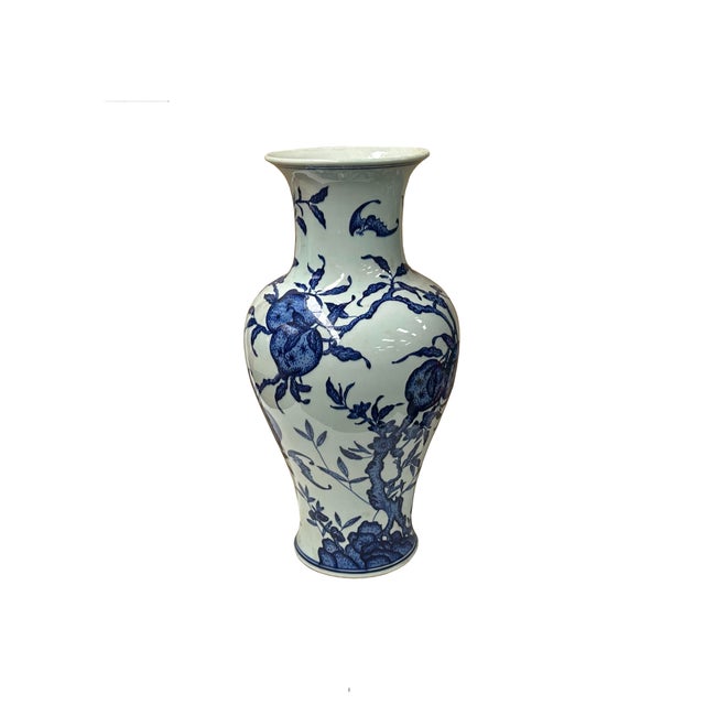 This elegant blue and white porcelain baluster vase features a classic, shapely silhouette with a gently flared rim, a...