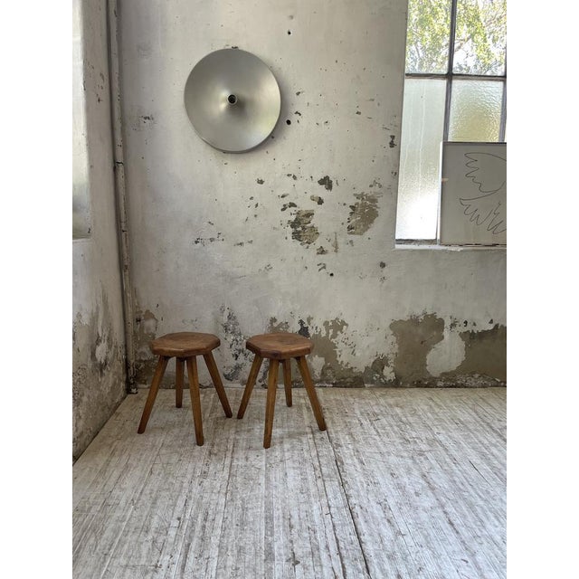 Set composed of two solid pine stools with tapered legs from the 1950s, with their thick hexagonal seat, nicely curved in...