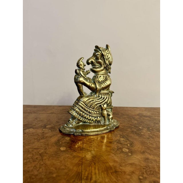 Unusual brass antique doorstop of Mrs Punch, having an unusual antique brass doorstop of Mrs Punch holding 'The Babe' on...