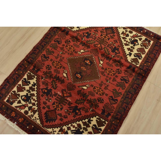 An authentic vintage tribal Hamedan rug hand-knotted with fine wool and natural dyes. This nomadic rug features a central...