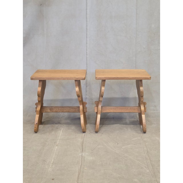 A charming pair of antique early 20th century solid white oak stools in an alpine or folk style, likely from Switzerland....