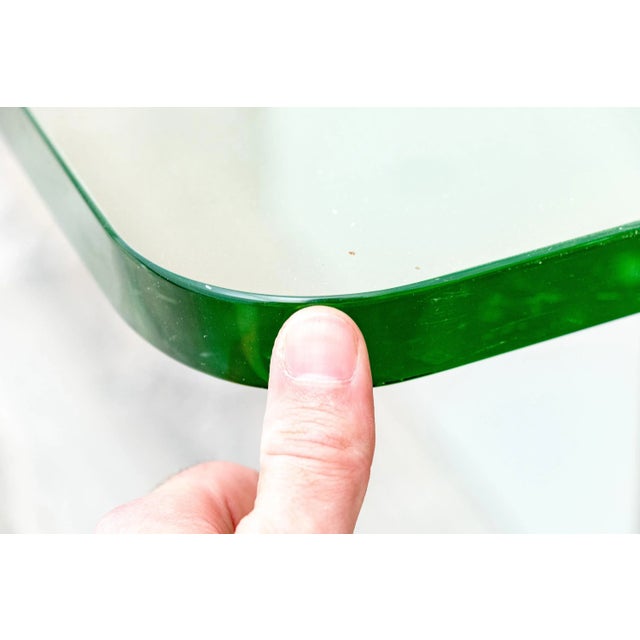 A vintage sleek and minimalist mid-century modern style coffee table with a one inch thick square glass top with rounded...