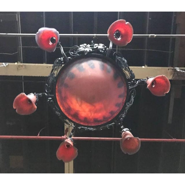 French Art Deco chandelier. Having a center glass bowl with six surrounding tulips in red and blue colored glass. With...