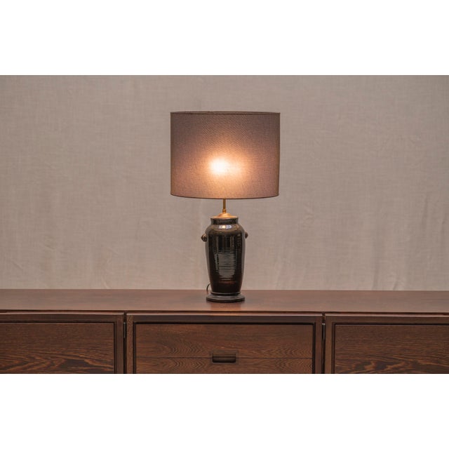 Elegant French table lamp from the 1970s, featuring a black glazed ceramic base with subtle Chinese-inspired influences....