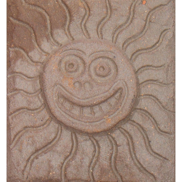 A studio pottery tile by the American artist Mark Bulwinkle (born 1946). This tile features the impressed image of a sun...
