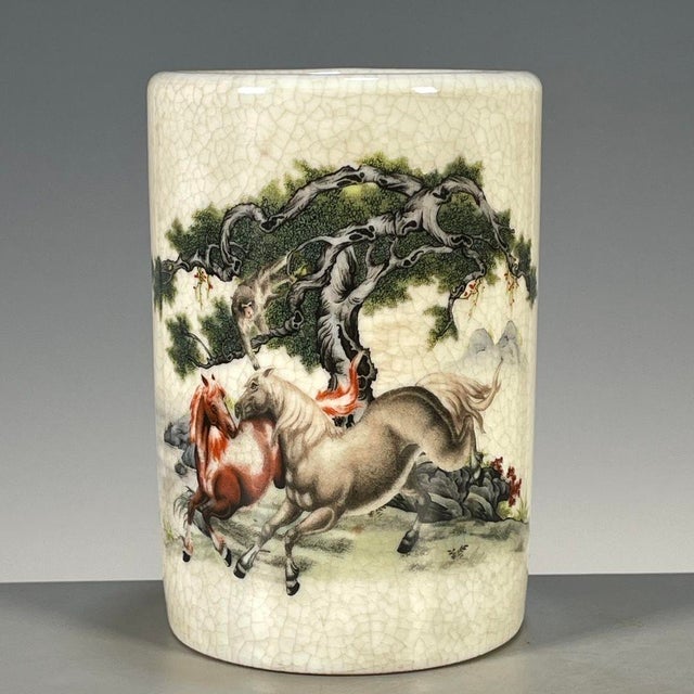 A charming Chinese porcelain brush pot (bitong). The cylindrical vessel features a creamy, all-over crackle glaze and is...