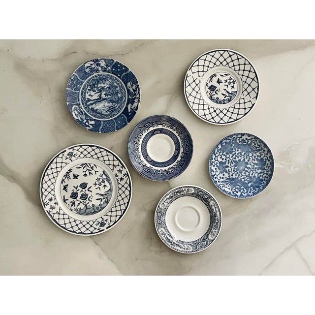 A set of six blue and white plates in a variety of sizes. Churchill England Saucer- 5 1/2 inches in diameter, 1 inch tall...
