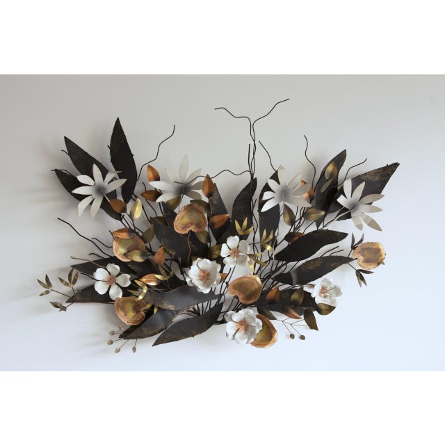 A large-scale mixed metal floral wall sculpture by Curtis Jere.in the artist's hand. The composition layers torch-cut...