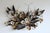 A large-scale mixed metal floral wall sculpture by Curtis Jere.in the artist's hand. The composition layers torch-cut...