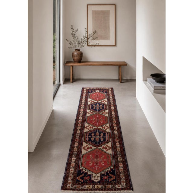 A finely detailed runner rug featuring repeating geometric medallions framed by intricate border patterns. The combination...