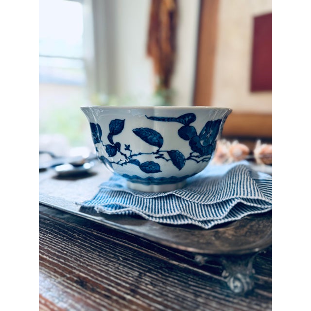 Beautiful vintage Japanese porcelain bowl featuring a rich royal blue floral and leafy branch design against a soft...