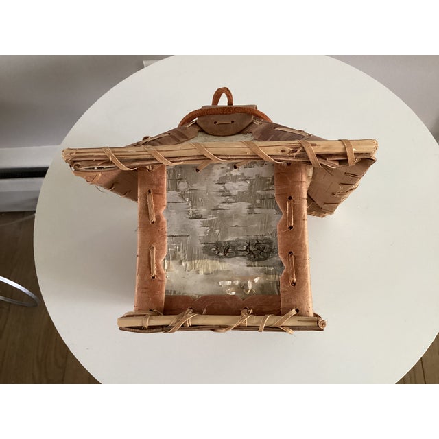 This charming birdhouse is made primarily of birchbark in shades of white, beige, gray and brown. The birchbark represents...
