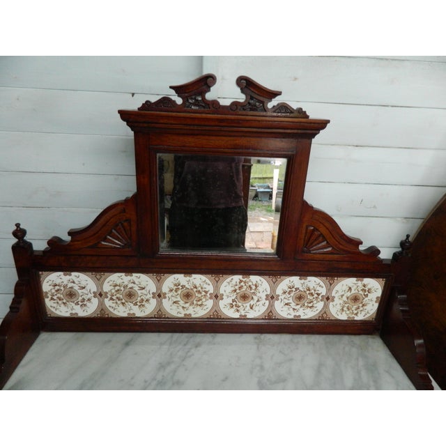 This Victorian marble wash stand with a tiled back mirror and 2 drawers is a charming piece of antique furniture that...
