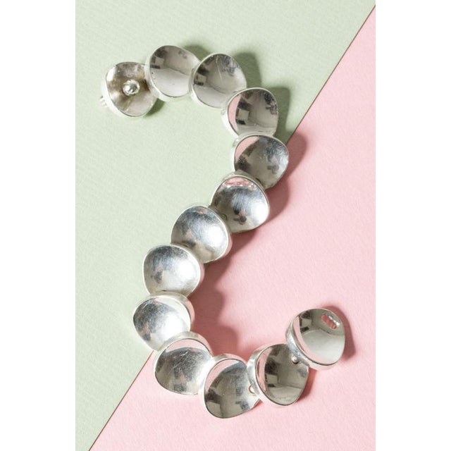 Elegant, luxurious silver bracelet by Bent Knudsen. Weighty concave links overlap and are locked with a decorative screw...