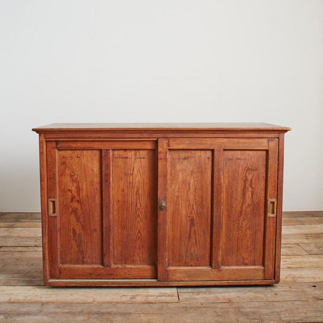 A beautiful pine school cupboard with sliding doors and internal adjustable shelf. The doors have brass handles. Perfect...