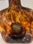 Hand blown faux tortoiseshell glass decanter with decorative brass stopper and brass inserts. The front insert has a Vodka...
