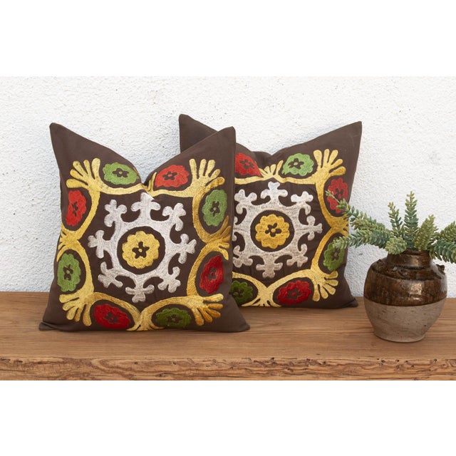 A stylized floral medallion anchors the center of each pillow in this well-matched pair — radiating mustard-gold tulip...