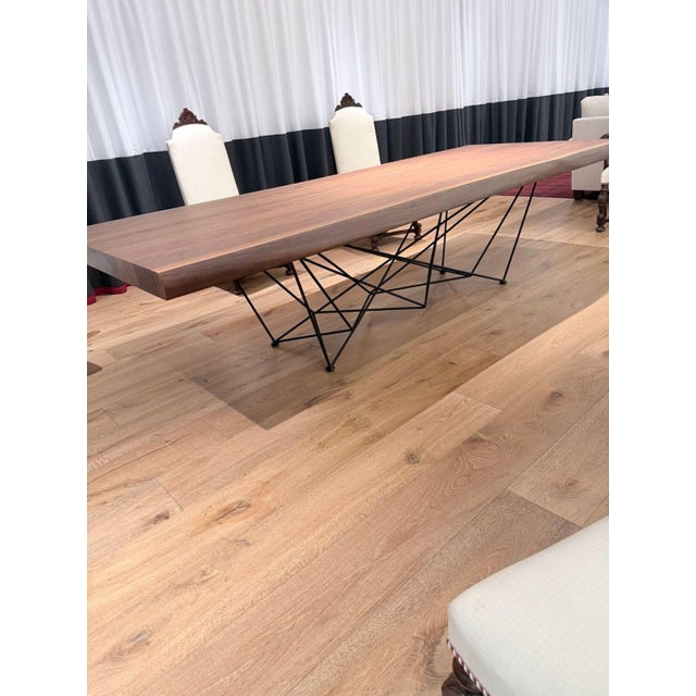 This Cattelan Italia dining table features a solid wood top with a natural edge and a unique grain pattern, giving it a...