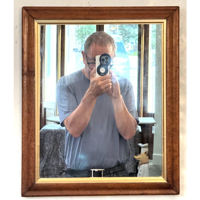 A fine English rectangular mirror featuring a handsome ogee frame of patinated curly maple with a giltwood 'slip' around...