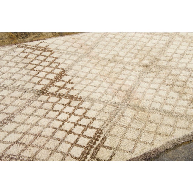 Hand-knotted in wool and originating circa 1950-1959, this 6x10 vintage Moroccan berber rug joins Rug & Kilim’s Moroccan...