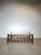 A striking mid-century coffee table featuring a robust wooden frame with a clear glass top. The architectural design of...