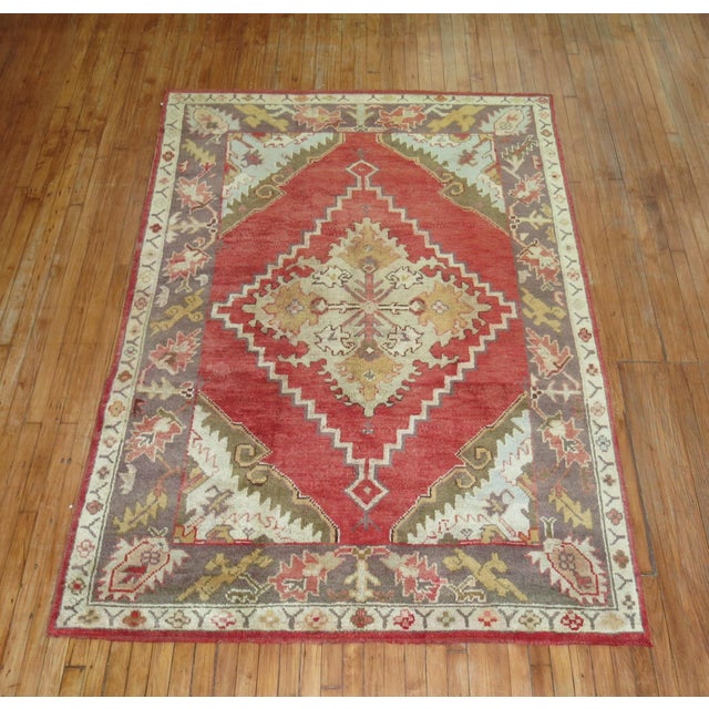 Early 20th-century Turkish Oushak rug with a medallion and border pattern on a red field Measures: 5'7" x 7'9".