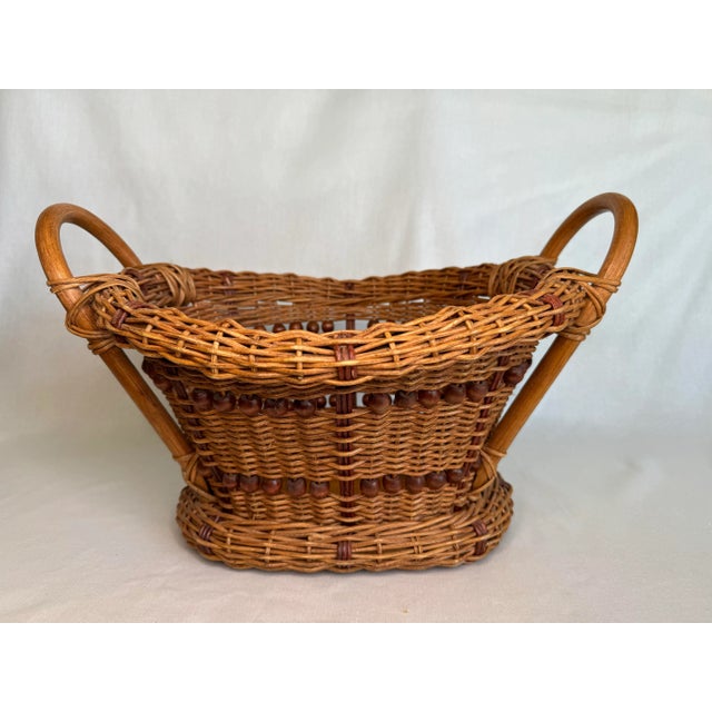 This attractive wicker basket was made using the over and under technique with bentwood handles and wood beaded trim. The...