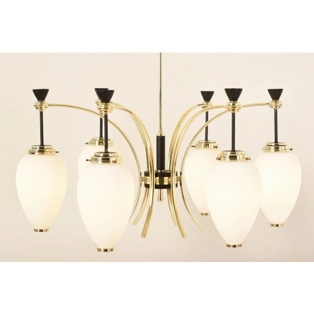 This chandelier by Stilnovo was produced in the 1960s. The frosted glass of the reflectors offers the best diffusion and...