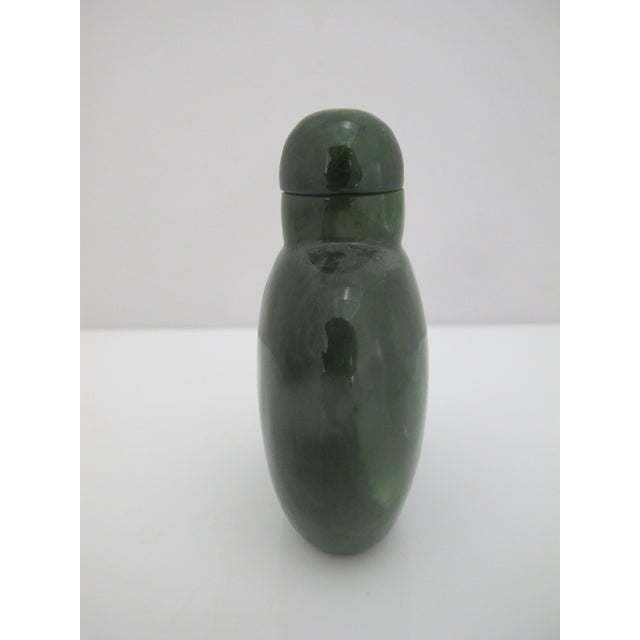 Antique Chinese snuff bottle carved from single spinach green jade stone with matching stopper. Measures 3" tall x 2 3/8"...