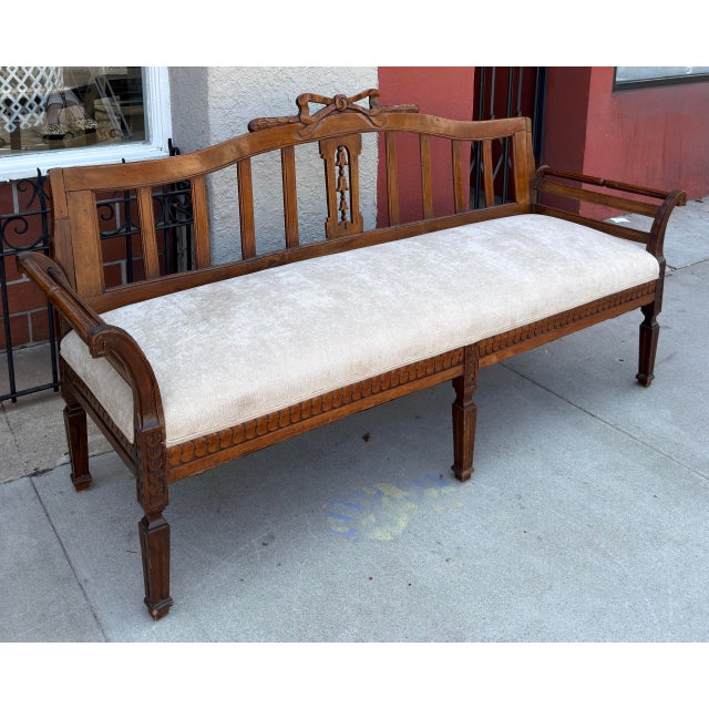 19th-century Swedish Gustavian settee features detailed hand-carving, including a bow motif on the crest rail and egg-and-...
