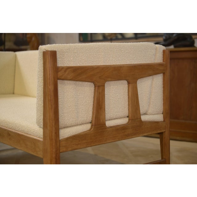 An elegant modernist sofa from the 1960s, crafted from solid oak and attributed to Robert Guillerme & Jacques Chambron for...