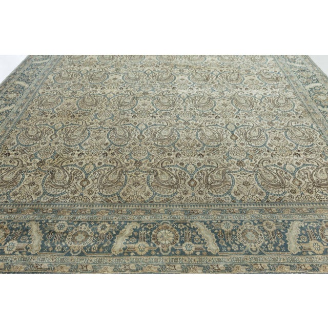 The antique Persian Tabriz rug shown above features a paisley pattern on a grid of alternating rosettes and palmettes. The...