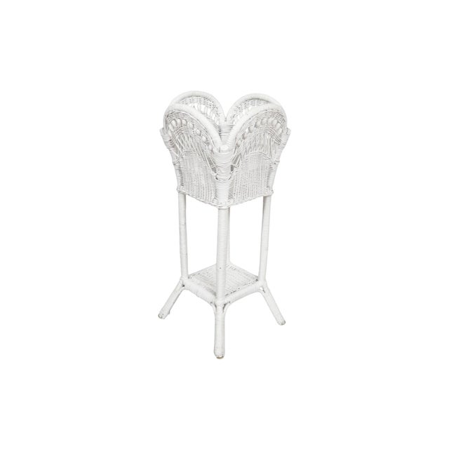 A white wicker woven rattan and bamboo plant stand circa 1920. The bamboo frame is tightly wrapped with rattan, and...