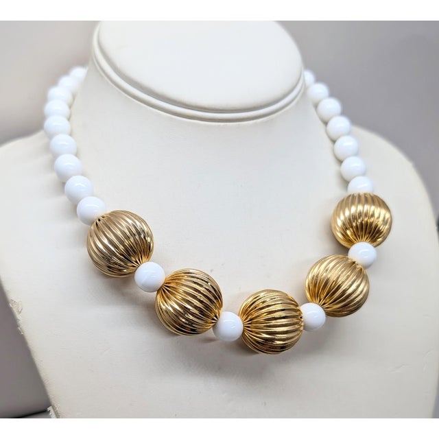 1980s goldtone with spherical ribbed beads in the front with spherical white resin bead spacers and identical beads up the...