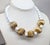1980s goldtone with spherical ribbed beads in the front with spherical white resin bead spacers and identical beads up the...