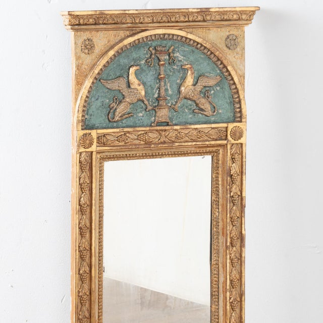 Lovely decorative trumeau mirror with applied carved accents including pair of griffins, decorative garland, floral...