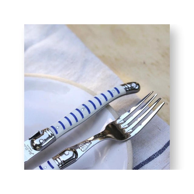 Late 20th century Jean Dubost Laguiole 24-piece cutlery set featuring the classic Mariniere stripe handle design. Crafted...