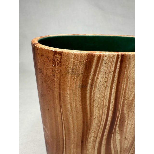This Mid-Century Modern American pottery by Romco, U.S.A. is in a faux finish mimicking a wood grain. A smooth painted...