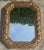 Vintage Italian octagonal mirror with a deeply carved frame featuring fruit, leaves, and foliage throughout. The frame has...