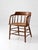 This antique cane seat captain’s chair features a curved crest rail with shaped arms, turned spindle supports, and a hand-...