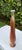 Hand-thrown studio pottery vase with a tall sculptural form and earth tone drip glaze in rust, ochre, cream, and gray....