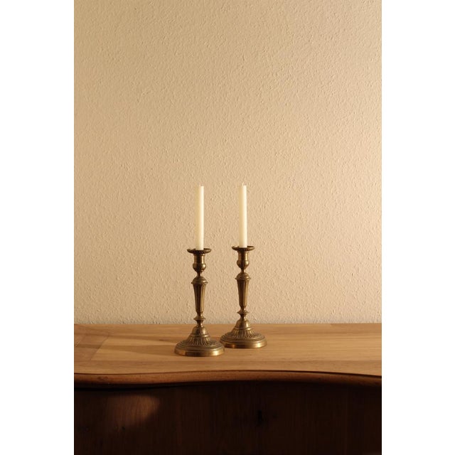 A refined pair of 19th-century French candlesticks in beautifully fluted brass, showcasing elegant vertical detailing and...