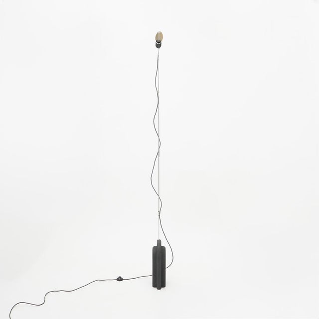 Slender and radically essential, the “Suro” floor lamp, designed by Ennio Chiggio for Lumenform in the 1970s, fully...