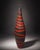 A tall sculptural floor vase with a bold black and red striped finish. The elongated silhouette and graphic stripe pattern...
