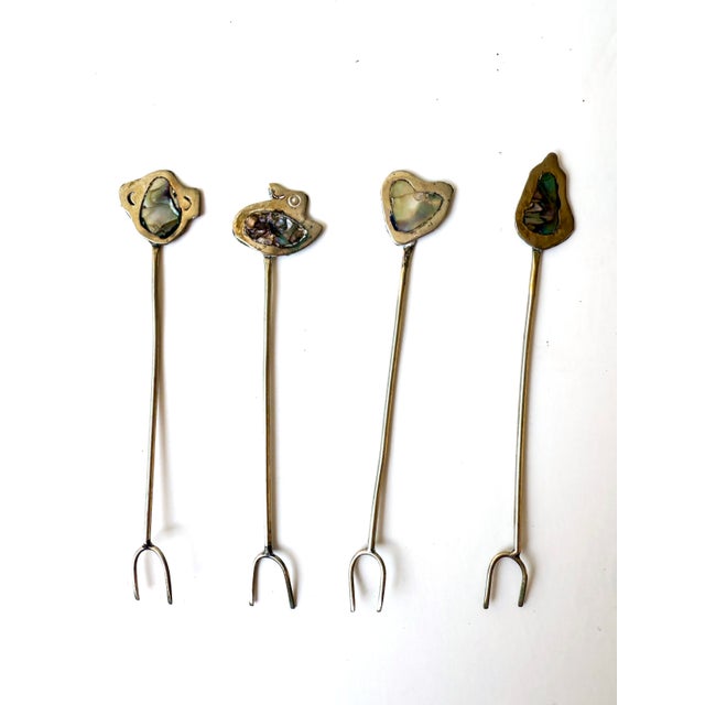 Charming set of twelve handmade Mexican silver picks with abalone inlay, each topped with a unique Southwest-themed...