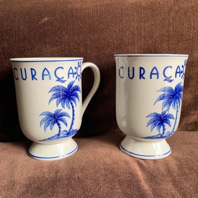 These vintage Delft handpainted Delfleur mugs with Curacao motif have an unusual footed shape and are in excellent...