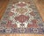 An antique Persian Bakhtiari rug with large scale all-over tribal medallion design on an antique white background....