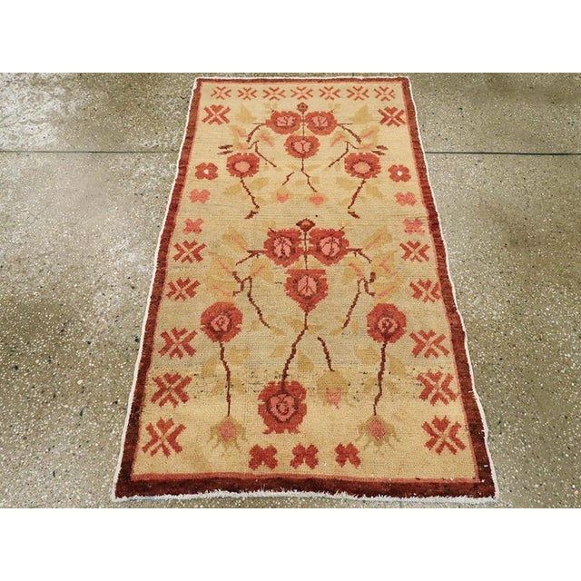 A vintage Turkish Anatolian throw rug. The old ivory ground displays a doubled module, each comprising five pink stylized...
